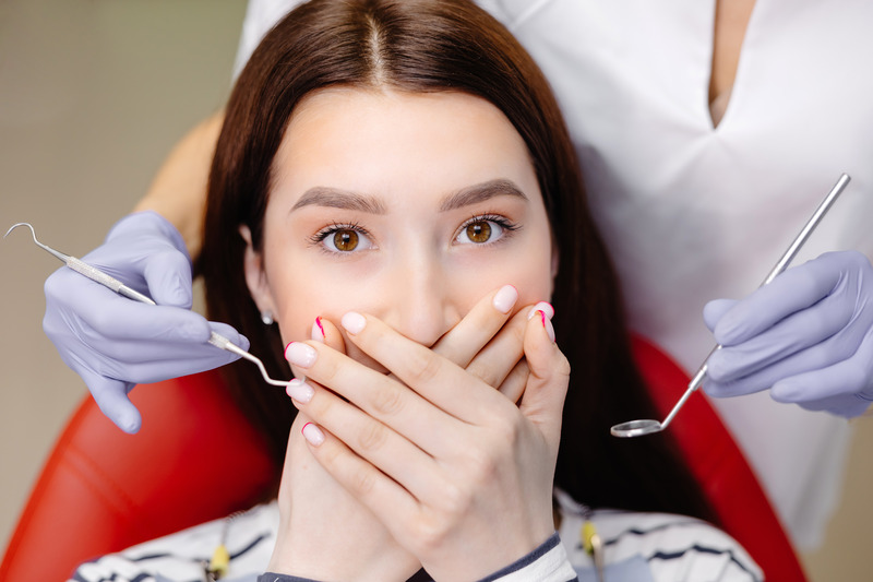 Patient covering their mouth to prevent a tooth extraction